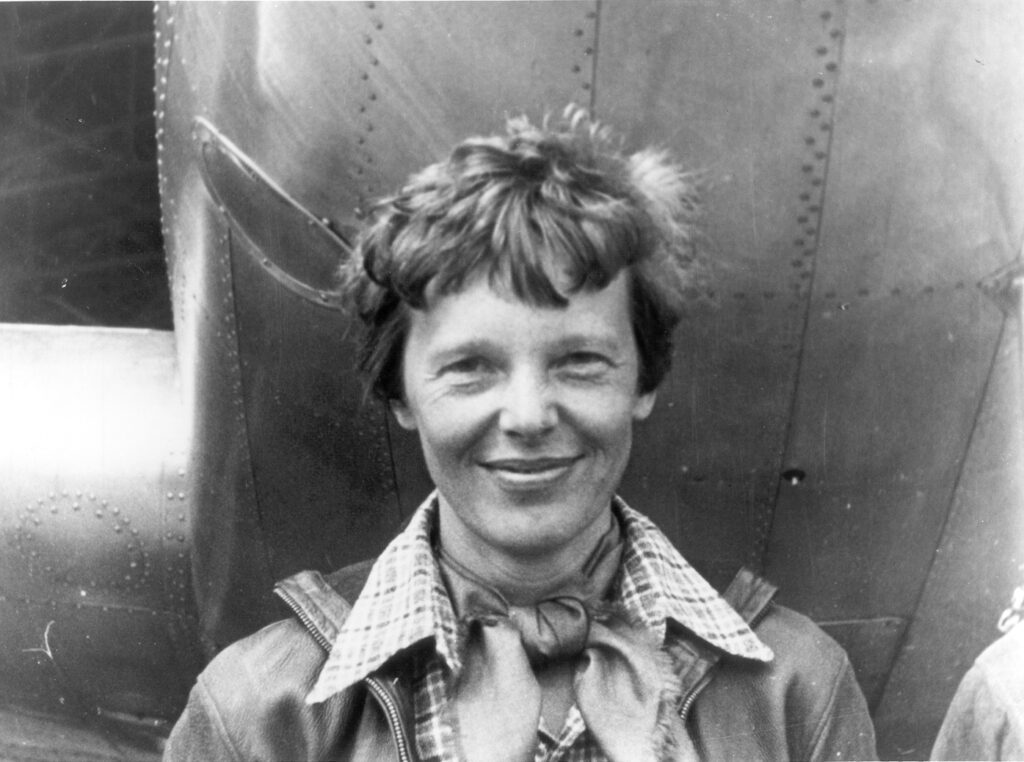 Amelia Earhart standing under the nose of her aircraft, a Martin Electra, March 1937. She disappeared in the Pacific on July 2, 1937.