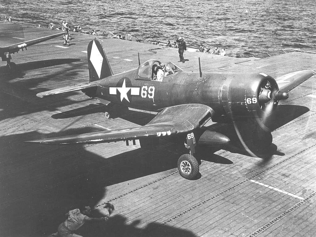 F4U-1D of VF-5 on USS Franklin (CV-13) 1945 receiving permission to take off from member of the deck crew. US Navy National Museum of Naval Aviation. The white diamond on the plane's tail identifies it as being from Franklin.