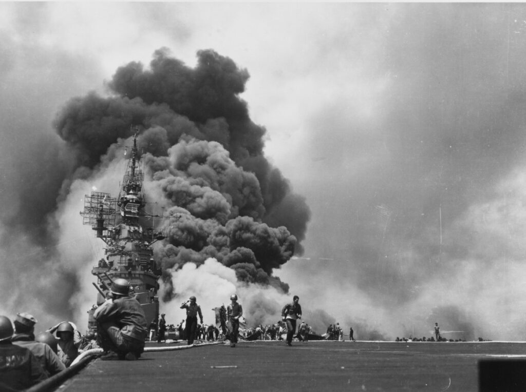 Massive smoke clouds and flames issue from USS Bunker Hill on 11 May 1945 strikes by two kamikazes. (US Navy 80-G-274266)