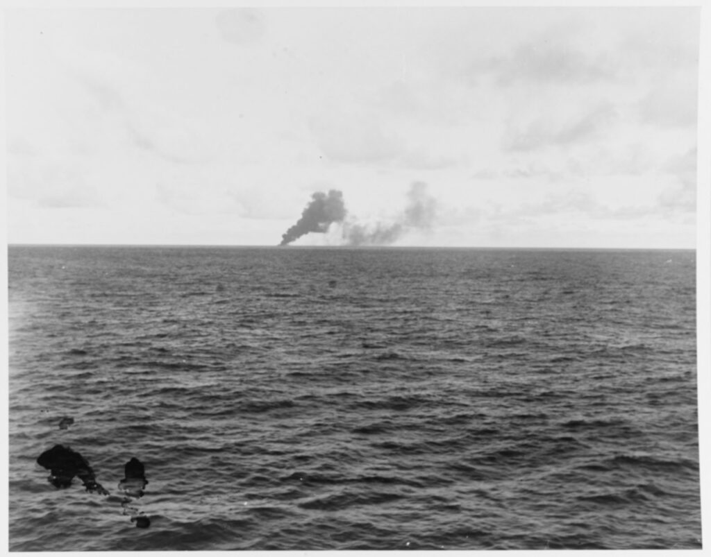 On the horizon, Japanese carrier CHIYODA burning after being shelled by U.S. cruisers, during the battle off Cape Engano, 25 October 1944.