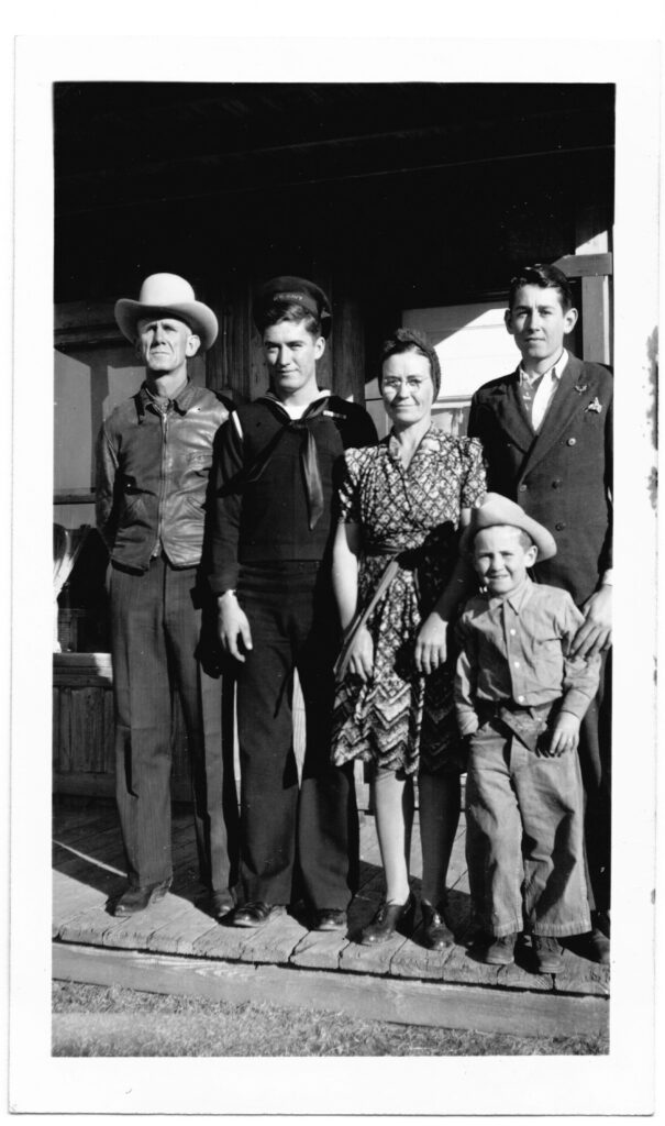 Five members of the Rogers family shown in a black and white photo standing on a wooden porch. Ancel, Elden, Grace, 5 year-old Jerry, and Gerald, the other son.