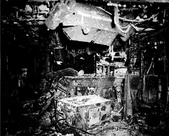 Photo of damage below decks on USS Franklin. Burned equipment and debris are shown.