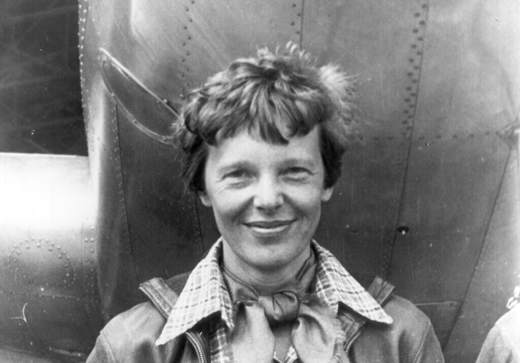 Amelia Earhart standing under the nose of her aircraft, a Martin Electra, March 1937. She disappeared in the Pacific on July 2, 1937.