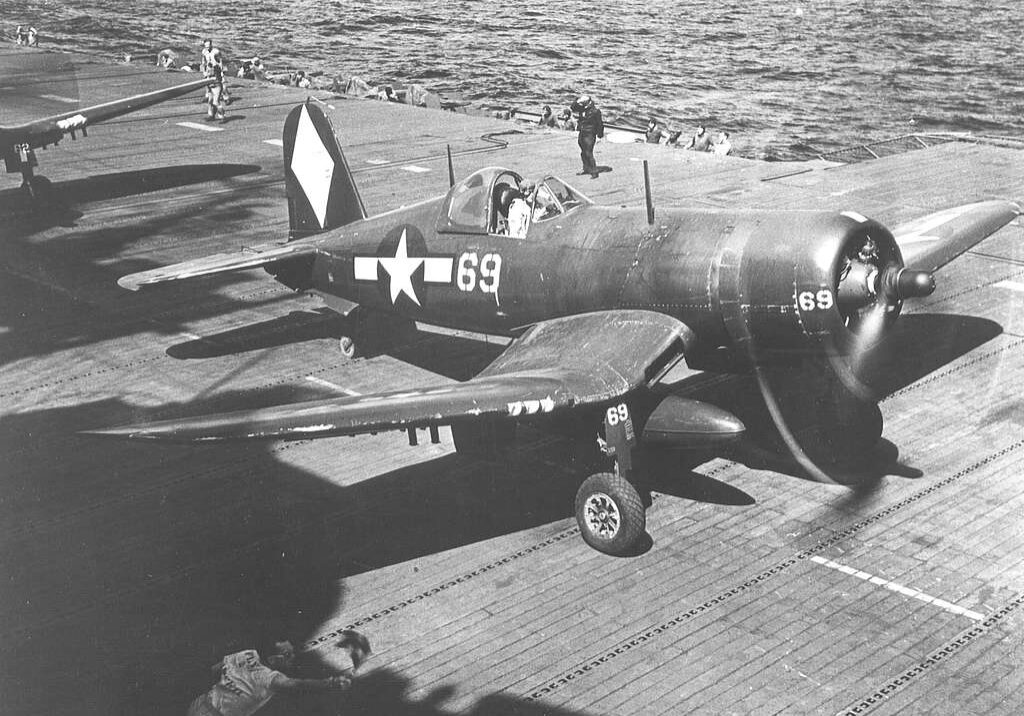 F4U-1D of VF-5 on USS Franklin (CV-13) 1945 receiving permission to take off from member of the deck crew. US Navy National Museum of Naval Aviation. The white diamond on the plane's tail identifies it as being from Franklin.