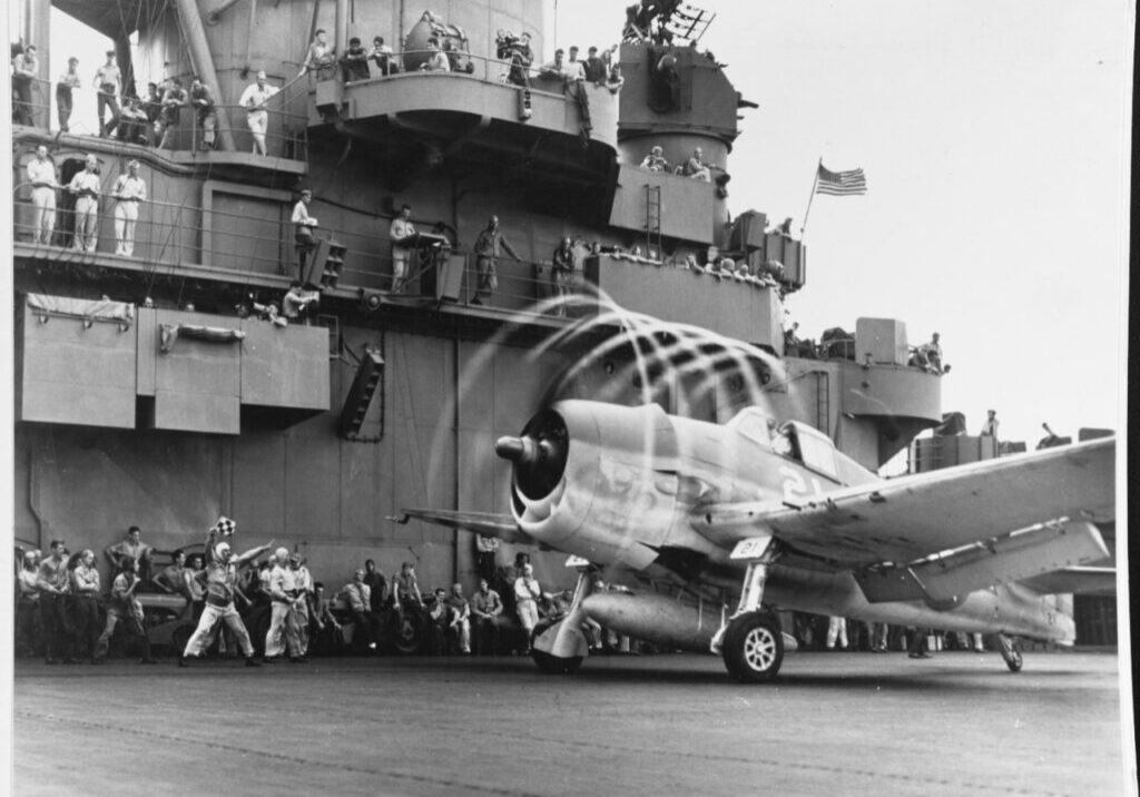 A Grumman F6F-3 Hellcat fighter makes condensation rings as it awaits the take-off flag aboard USS Yorktown (CV-10), 20 November 1943. The plane is from Fighting Squadron Five (VF-5). Yorktown was then hitting targets in the Marshall Islands to cover the landings in the Gilberts. VF-5 would serve onboard Franklin in 1945. By that time, flying Corsairs.