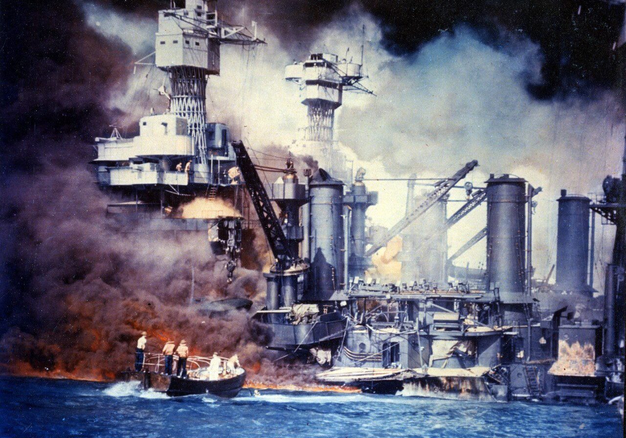 Sailors in a motor launch rescue a survivor from the water alongside the sunken USS West Virginia (BB-48) during or shortly after the Japanese air raid on Pearl Harbor. USS Tennessee (BB-43) is inboard of the sunken battleship. Photograph from the Army Signal Corps Collection in the U.S. National Archives. Catalog #: USA C-5904