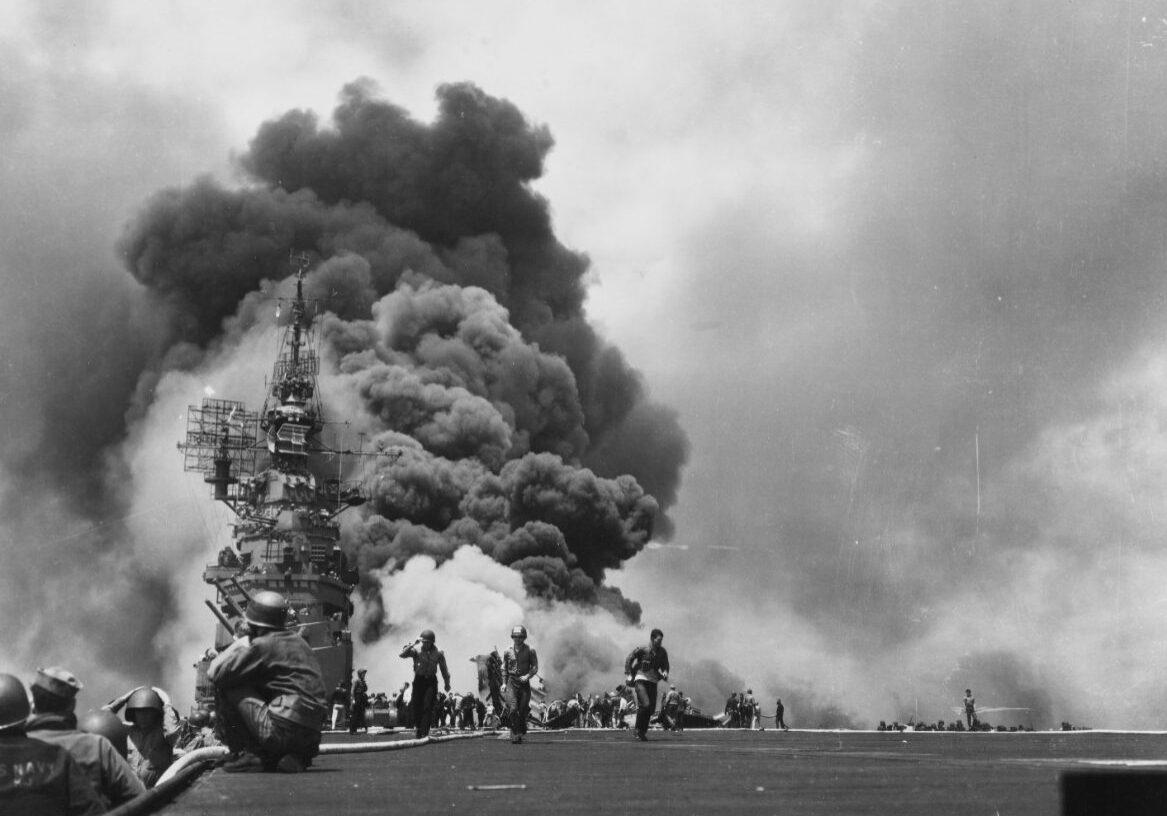 Massive smoke clouds and flames issue from USS Bunker Hill on 11 May 1945 strikes by two kamikazes. (US Navy 80-G-274266)
